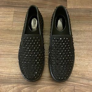 Black studded Michael Kors slip on sneakers.